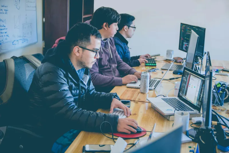 Équipe de développeurs travaillant ensemble sur des laptops